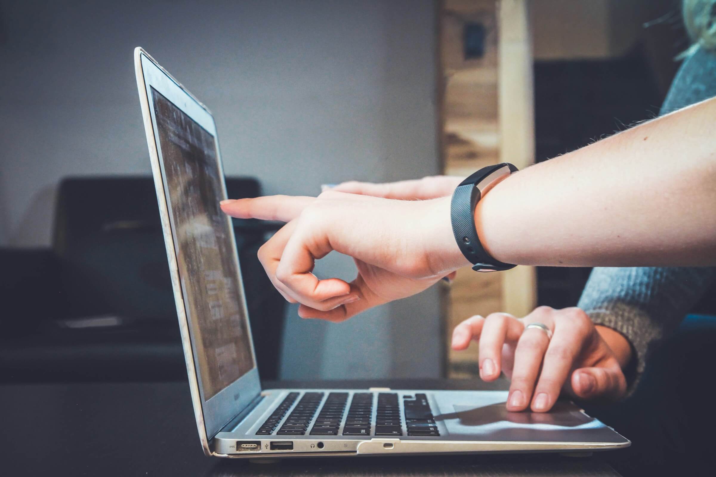 A photo of people working together at a laptop